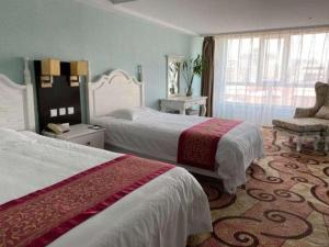ハルビン市にあるLongda Ruiji Business Hotel Harbinのベッド2台と椅子があるホテルの部屋 +252枚の写真
