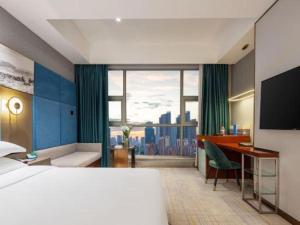 a hotel room with a bed and a desk and a large window at Wuhan Tieqiao Jianguo Hotel in Wuhan +185 photos