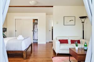 a bedroom with a bed and a couch and a table at Liahona Guest House in Ucluelet