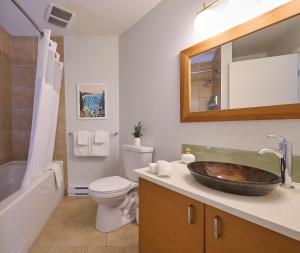 a bathroom with a sink and a toilet and a tub at Liahona Guest House in Ucluelet +29 photos