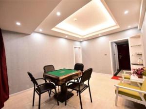 ein Zimmer mit einer Tischtennisplatte und schwarzen Stühlen in der Unterkunft Dali Dayu Hotel in Dali