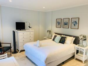 a bedroom with a white bed and a tv at Balmoral Salt in Sydney