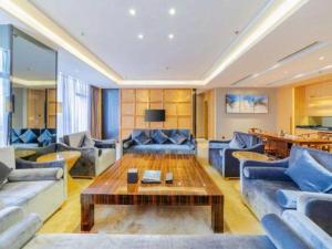Una sala de estar con sofás y una mesa de café. en Golden Phoenix International Hotel, en Xiahuangtang