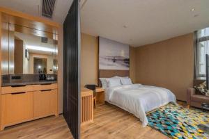 a hotel room with a bed and a kitchen at Qingdao Elegance Hotel in Qingdao