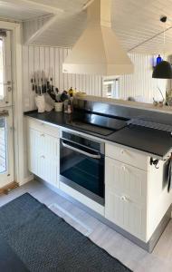 a kitchen with a black stove top oven at Cozy Summer House With 100 Meters To The Sea in Haderslev +12 photos