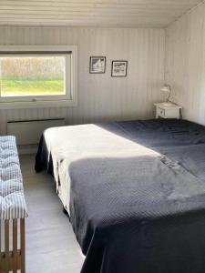 a bedroom with a large bed and a window at Cozy Summer House With 100 Meters To The Sea in Haderslev