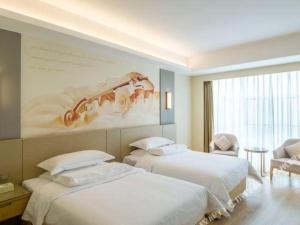 2 letti in una camera d'albergo con un dipinto sul muro di Vienna International Hotel Chengdu New International Conference and Exhibition Center Branch a Chengdu Altre 151 foto