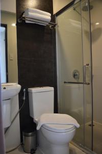 a bathroom with a toilet and a glass shower at Mango Suites - Isabela in Santiago City