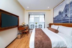 Habitación de hotel con cama grande y TV de pantalla plana. en James Joyce Coffetel Wuhan Huanlegu Renhe Road Subway Station, en Wuhan