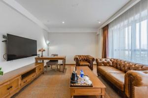 石家荘市にあるJames Joyce Coffetel Shijiazhuang Century Park Shiji Huamaoのソファと薄型テレビのあるリビングルーム