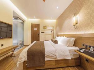 una camera d'albergo con un letto grande e una televisione di James Joyce Coffetel Qufu Tourist Center Gulou Street Sankong Scenic Spot a Qufu Altre 202 foto
