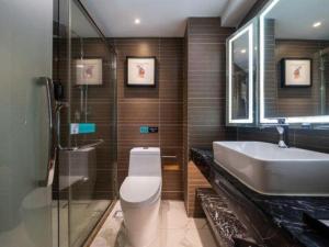 a bathroom with a toilet and a sink and a mirror at Xana Hotelle Xiamen Airport Zone Government in Xiamen +37 photos
