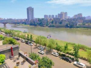 een uitzicht op een rivier met auto's geparkeerd op een parkeerplaats bij Xana Lite Neijiang Zizhong Shanghehui Branch in Shuinan