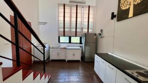 a kitchen with a refrigerator and a staircase in it at Stylish Loft Condo in Boat Avenue Phuket in Ban Thalat Choeng Thale