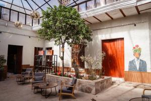 a lobby with tables and chairs and a tree at Way Kap Hostel Arequipa in Arequipa