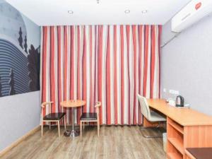 a room with a striped curtain and a table and chairs at Thank Inn Plus Hotel Zhuhai Nanping pedestrian Street Huafa shopping Center in Zhuhai