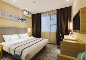 a hotel room with a large bed and a desk at City Comfort Inn Guangzhou Tianhe District Tangxia Exhibition Center in Guangzhou +214 photos