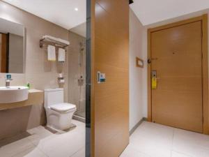 a bathroom with a toilet and a sink and a door at City Comfort Inn Shanghai International Automobile City Tongji University in Anting Zhan