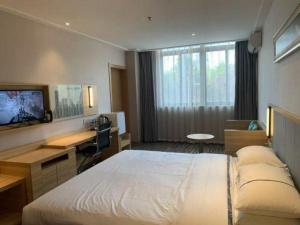 a hotel room with a large bed and a desk at City Comfort Inn Shanghai International Automobile City Tongji University in Anting Zhan