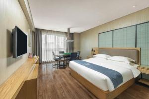 a bedroom with a large bed and a dining room at Echarm Hotel Changde Chaoyang D5 District in Changde