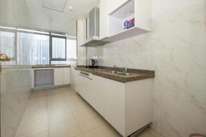 une cuisine blanche avec un évier et un comptoir dans l'établissement Borrman Hotel Guilin High-speed Railway North Station Evergrande Plaza, à Guilin