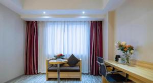 a hotel room with a desk and a chair and a table at City Comfort Inn Zhanjiang Mazhang Pedestrian Street High-speed Railway West Station in Zhanjiang