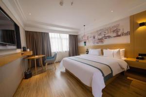 Una habitación de hotel con una cama grande y un escritorio. en City Comfort Inn Changsha Railway Station Amiling Metro Station, en Changsha
