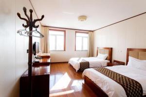 a hotel room with two beds and two windows at GreenTree Alliance Hotel Tianjin Jinnan District Gegu Stadium in Tianjin +55 photos