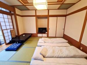 Una habitación con dos camas y un televisor. en Uruoikan, en Nagano