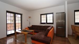uma sala de estar com um sofá e um frigorífico em Vila Olympia - Apartmán Olympia 3 em Ruzomberok