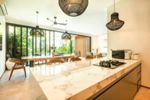 an open kitchen and dining room with pendant lights at New 4BR Villa 200m to the beach Canggu in Canggu