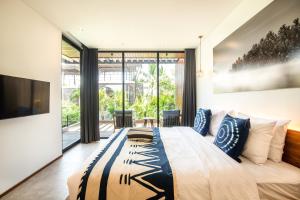 a bedroom with a large bed with blue and white pillows at New 4BR Villa 200m to the beach Canggu in Canggu +91 photos