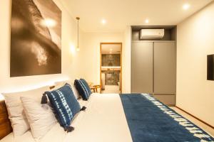 a bedroom with a white bed with blue pillows at New 4BR Villa 200m to the beach Canggu in Canggu