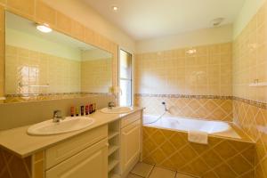 a bathroom with two sinks and a bath tub at Madame Vacances Villas la Clairière aux Chevreuils in Moliets-et-Maa +13 photos
