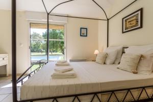 a bedroom with a large bed with towels on it at Madame Vacances Villas la Clairière aux Chevreuils in Moliets-et-Maa