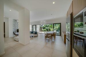 a kitchen and living room with a table and chairs at Garden level apartment, beach 8min walk in Grand Baie