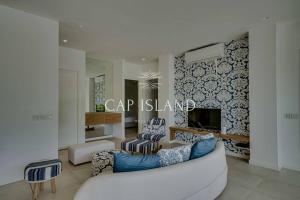 a living room with a white couch and a tv at Garden level apartment, beach 8min walk in Grand Baie
