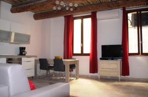 a living room with a table with chairs and a television at Le Pairou in Nice