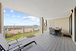 a balcony with a table and chairs and a view of the beach at White Caps 103 in Orange Beach