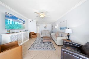 a living room with a couch and a tv at White Caps 103 in Orange Beach +25 photos