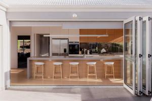 a kitchen with a bar with stools at Beachfront Estate with Tennis Court in Lauderdale