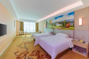 pokój hotelowy z 2 łóżkami i obrazem na ścianie w obiekcie Vienna Hotel Guangdong Huizhou High-Speed North Railway Station Xiaojinkou w mieście Huizhou +143 zdjęcia