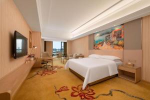 une chambre avec un grand lit blanc et un bureau dans l'établissement Vienna Hotel Shandong Shouguang International Exhibition Center, à Shouguang