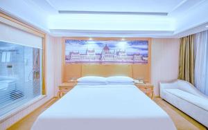 a bedroom with a large white bed and a window at Vienna Hotel Jiangxi Jiujiang Gongqingcheng High-Speed Railway Station in Gongqingcheng +67 photos