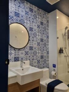 Un baño con lavabo, inodoro y espejo. en Eat Sleep Chann, en Chanthaburi