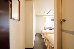 a room with two beds and a door to a bedroom at Hotel Sho Sapporo - Vacation STAY 61073v in Sapporo