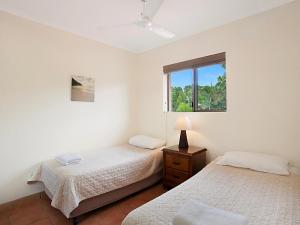 2 camas en una habitación blanca con ventana en Cayman Quays, en Noosaville