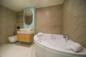 a bathroom with a tub and a sink and a toilet at BEAT Warii Hostel at Chaophraya River in Bangkok