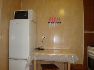 a small kitchen with a white refrigerator and some utensils at Apartments Colonnade in Kislovodsk