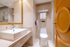 a white bathroom with a sink and a toilet at Vienna Hotel Shenzhen Qinghu Metro Station in Tiantangwei